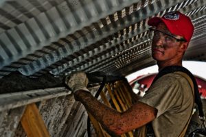 man repairing roof damage